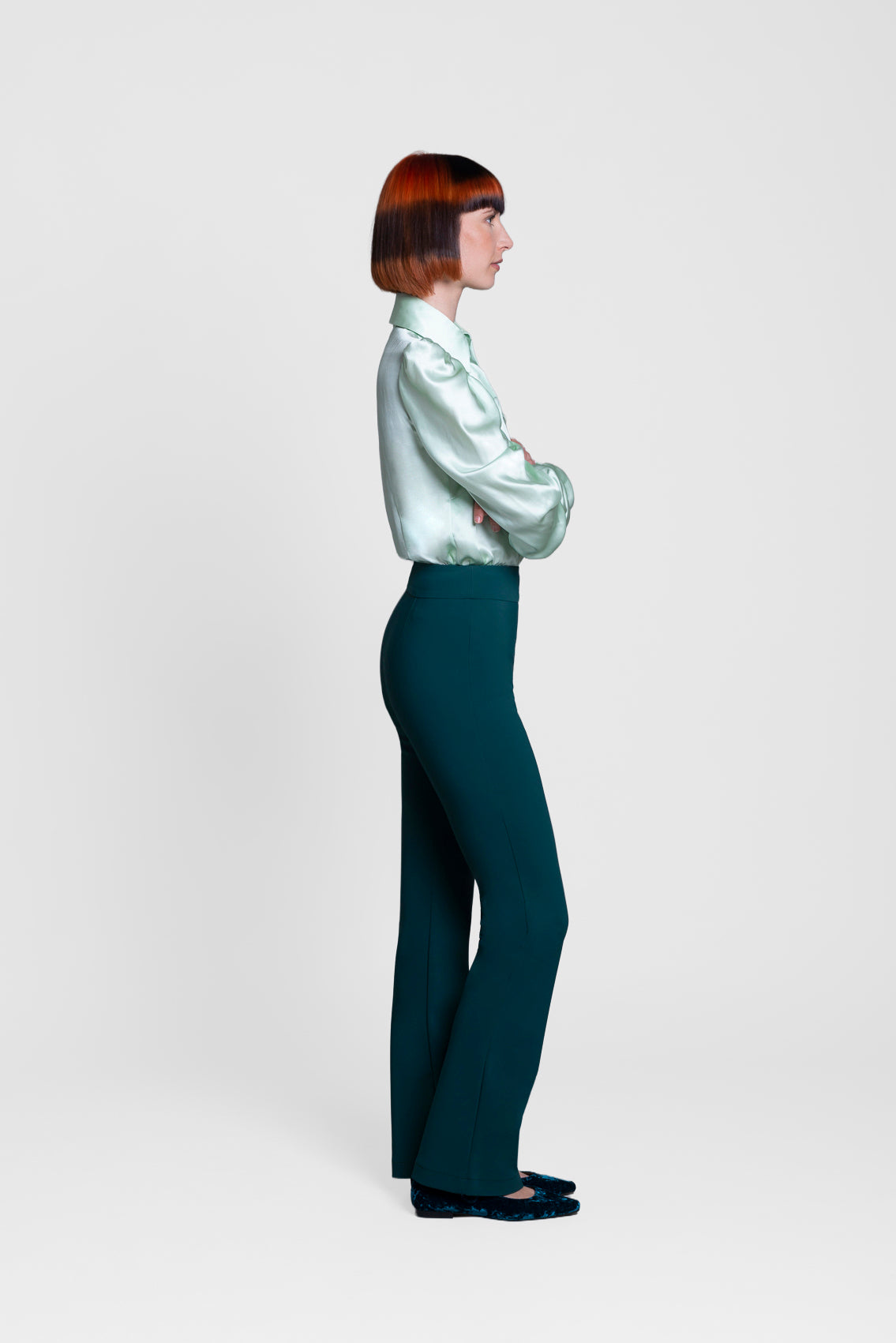Person wearing a light-colored shirt and dark pants on a white background