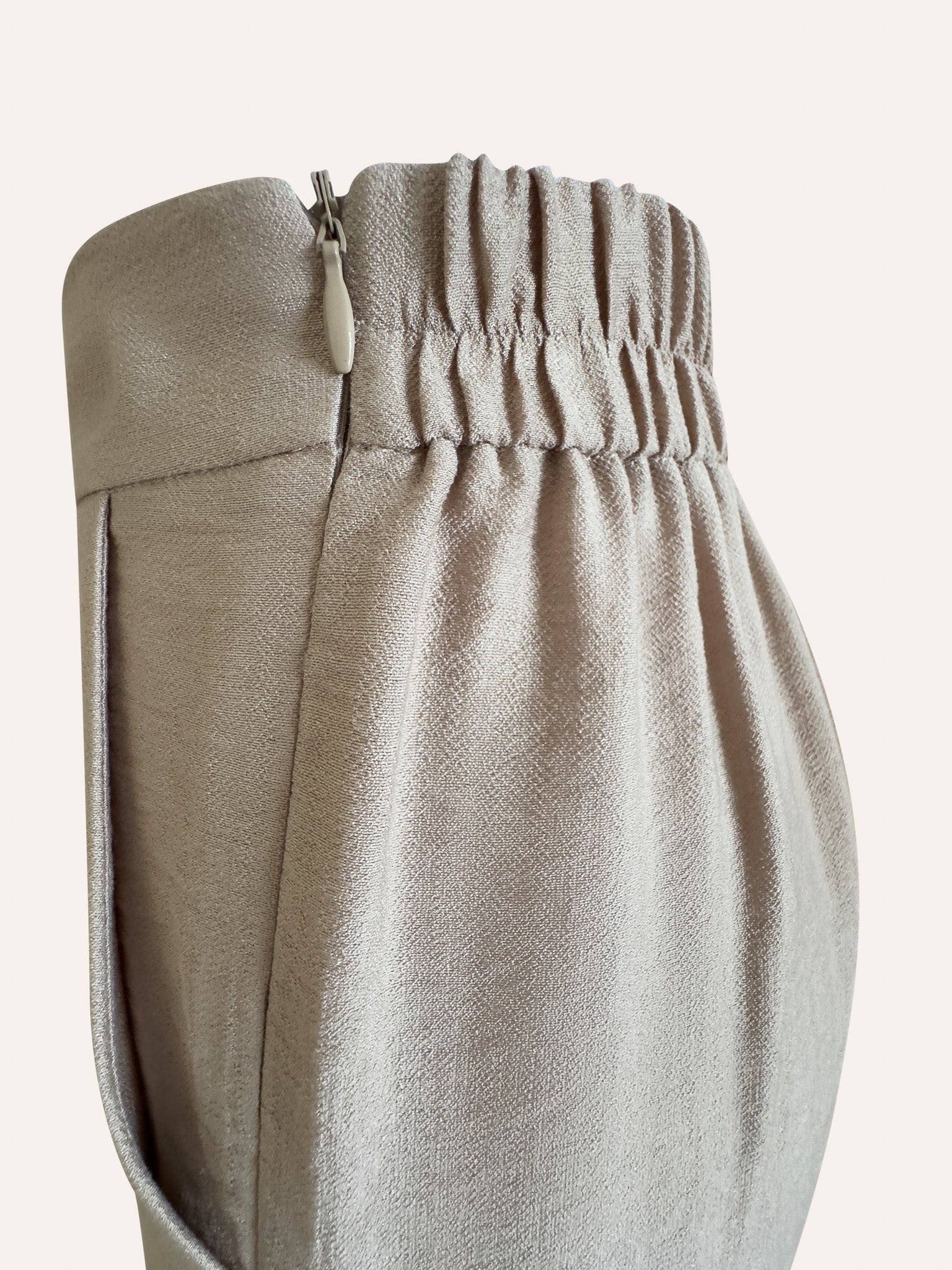Close-up of beige pants with an elastic waistband on a light background